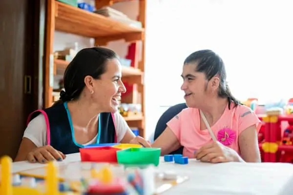 Mental Health Professional playing with Down Syndrome woman at School