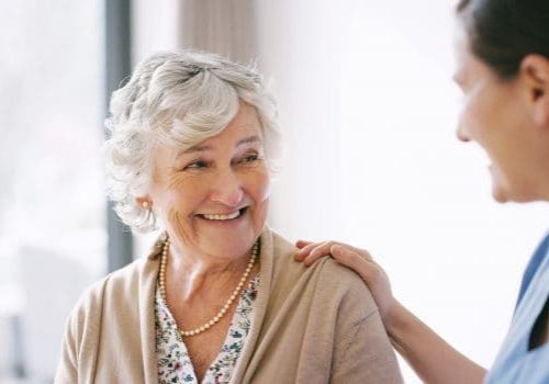 Shot of a happy senior woman being cared for by a young nurse in a retirement home