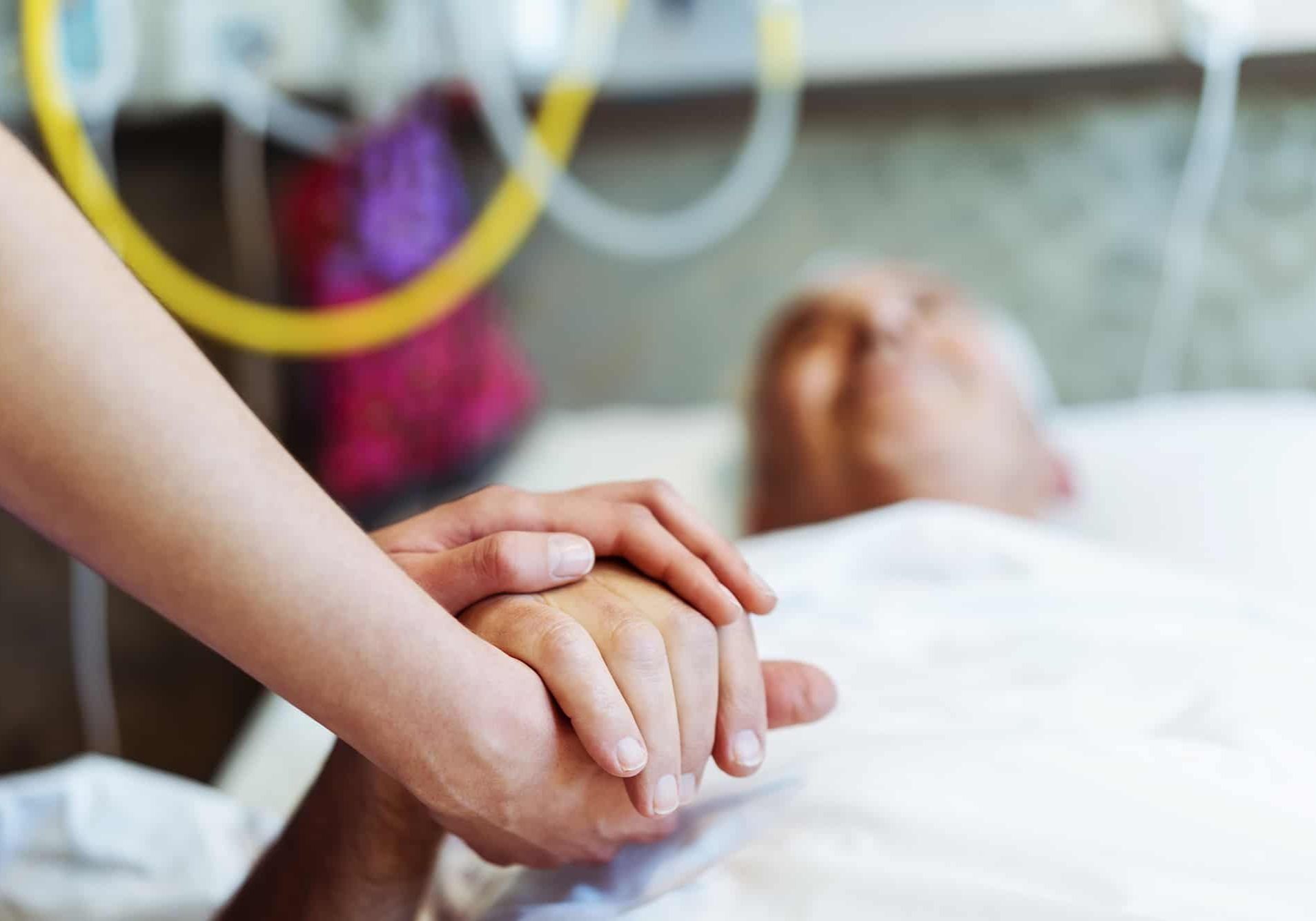 Cropped image of healthcare worker holding patient's hand. Close-up of nurse consoling patient. They are in hospital.